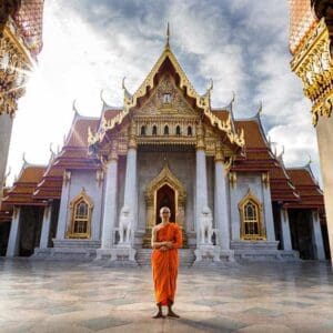 Buddhist monk standing in front of a temple in Bangkok Bangkok temple